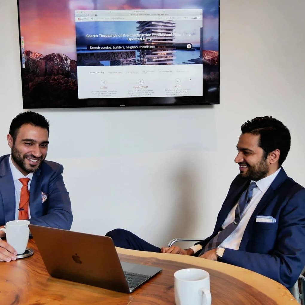 Amit and Roy Bhandari, Red Bricks co-founders, with the TalkCondo platform on screen behind them